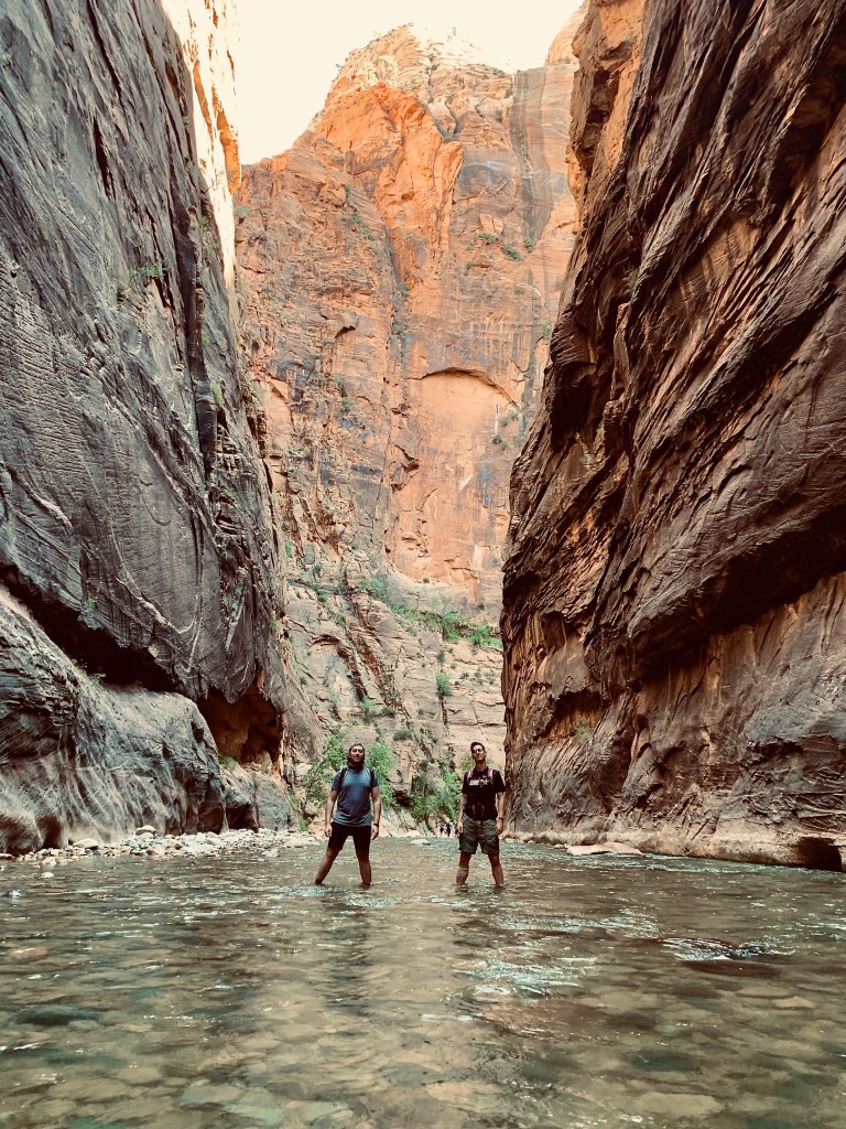 Two men hiking The Narrows in Zion National Park