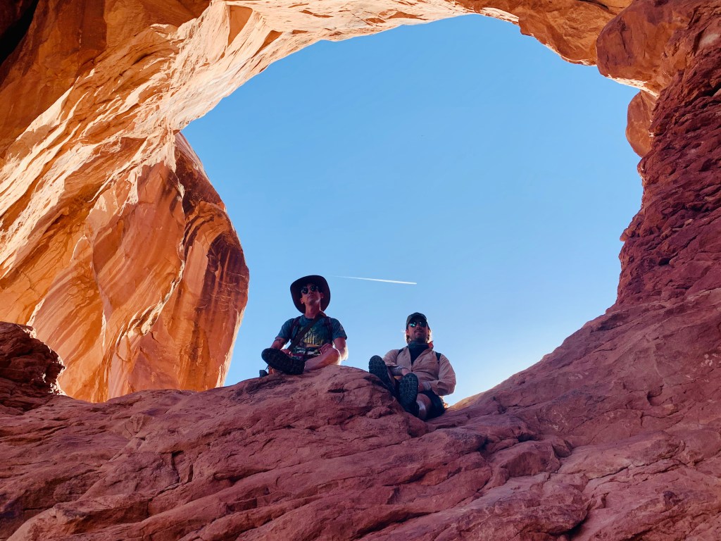 Two men hiking at Arches National Park in Utah